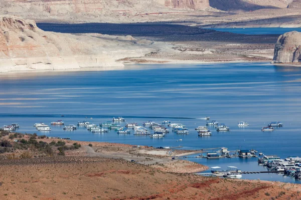 Large yachts and party boats fill the Wahweap Marina on the beautiful and scenic Lake Powell with eroded sandstone features in the distance near Page, Arizona.