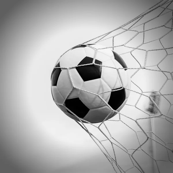 Pelota de fútbol en la red de gol — Foto de Stock