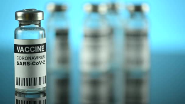 Coronavirus vaccine in glass bottle on mirror table — Stock Video
