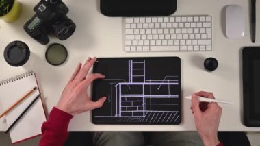 Ofis görünümündeki tablet üzerinde çalışan tasarımcı