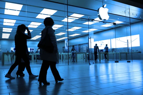 Un lado de la gente de compras dentro de la tienda de Apple con tonos azules —  Fotos de Stock