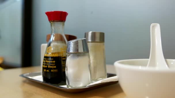 Женщина кладет соль на стол в китайском ресторане — стоковое видео