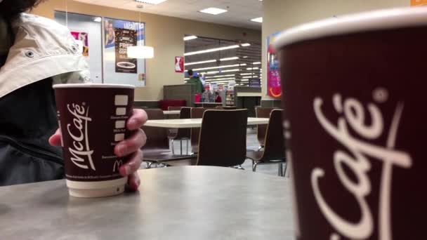 Woman drinking Mccafe coffee at mcdonalds fast food restaurant — Stock Video