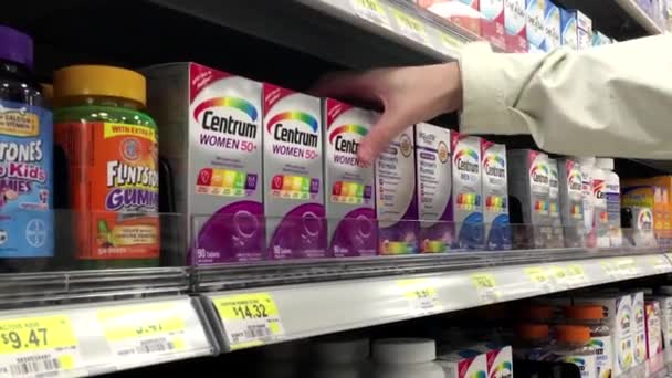 Kvinnan tar Centrum kvinnor 50 plus vitamin inne Walmart butiken — Stockvideo