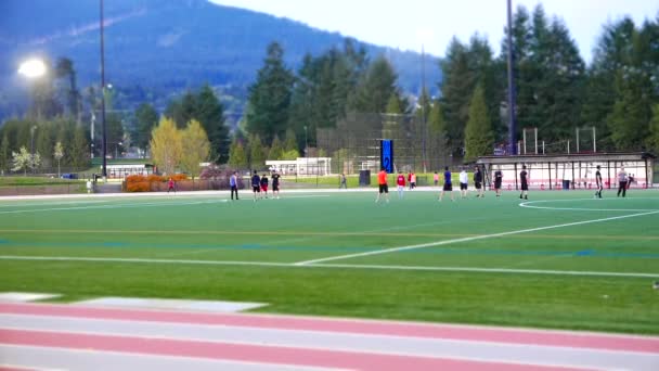 Pessoas correndo em pista de corrida e jogando futebol no parque com efeito em miniatura — Vídeo de Stock