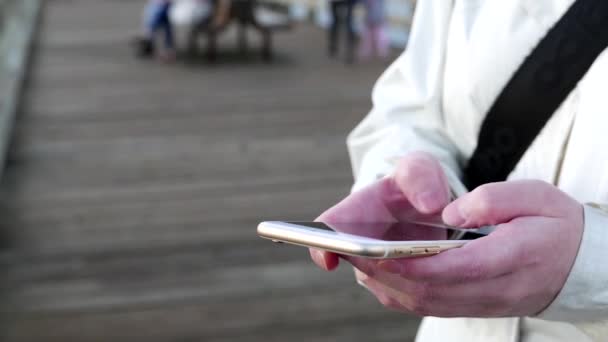 Kvinna att skriva meddelandet på smart telefon på Rocky peka park — Stockvideo
