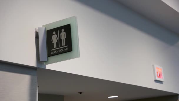 Mozgás a férfi és a nő mosdóba logó a falon — Stock videók