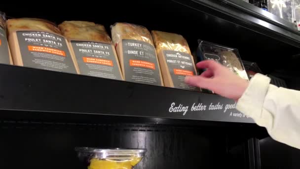 Vrouw plukt kip artisjok sandwich in Starbucks winkel — Stockvideo