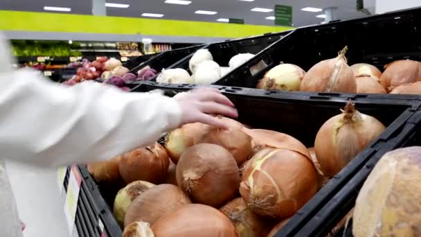 Женщина выбирает лук в отделе продукции магазина Walmart — стоковое видео