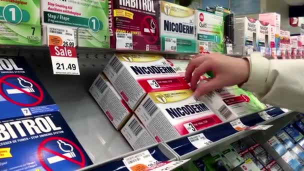 Personas que toman Nicoderm paso tres para el parche de nicotina dentro de la farmacia Shoppers — Vídeos de Stock