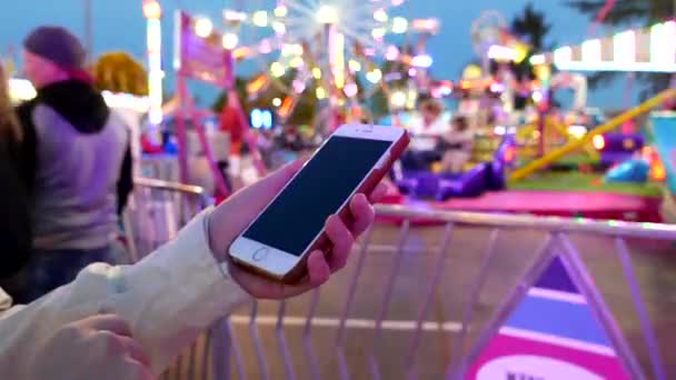 Närbild på kvinna med smart telefon på västkusten Amusements Carnival — Stockvideo