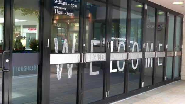 Ene kant van de ingang van het winkelcentrum met Welkom bord op de deur in het centrum van de stad Lougheed mall — Stockvideo