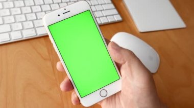 Özel içerik eklemek için çeşitli el jestleri, yeşil perde ile telefonu kullanan adam