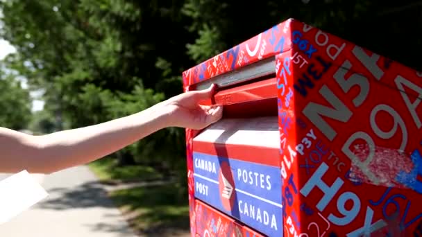 Mujer colocando correo en un buzón canadiense — Vídeos de Stock