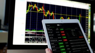 Döviz Kuru Döviz Kuru grafik üzerinde imac ile kontrol etmek için iPad kullanan adam