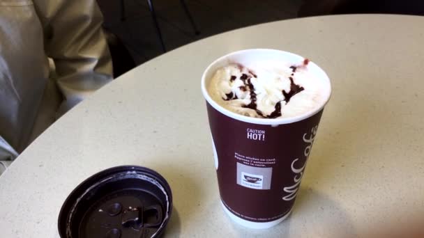 맥도날드의 패스트 푸드 레스토랑에서 따뜻한 커피를 마시는 여자의 움직임 — 비디오