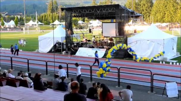 Tijdspanne van mensen lopen op stadion circuit met doorgifte voor leven sepcial evenement in coquitlam center park. — Stockvideo