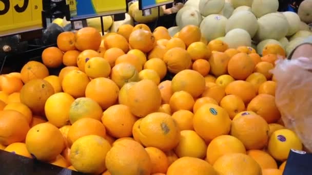 Mujer seleccionando naranja fresca en tienda de comestibles — Vídeos de Stock