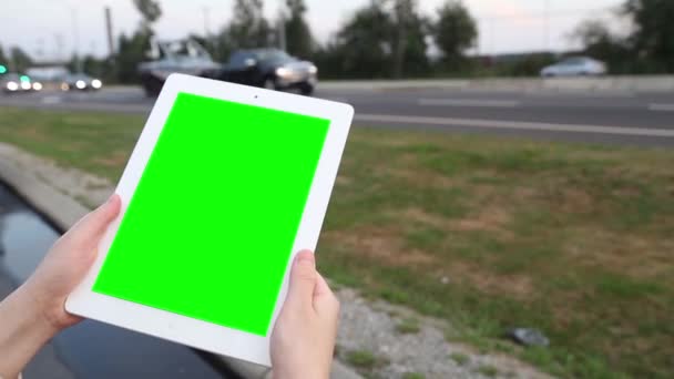 Uma mulher segura um tablet PC em branco com uma tela verde para o seu próprio conteúdo personalizado . — Vídeo de Stock