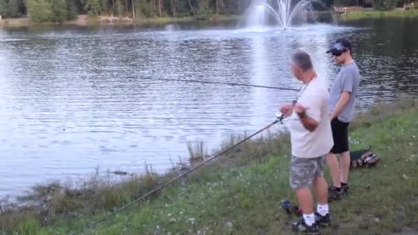 Hombre mostrando su habilidad de pesca al atardecer — Vídeo de stock