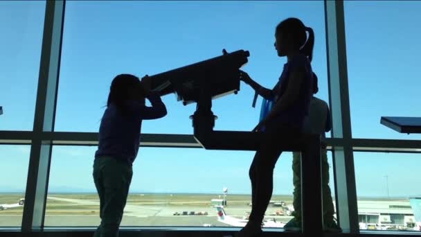 Silhouet van kinderen dicht omhoog kijkt door raam naar vliegtuigen op luchthaven — Stockvideo