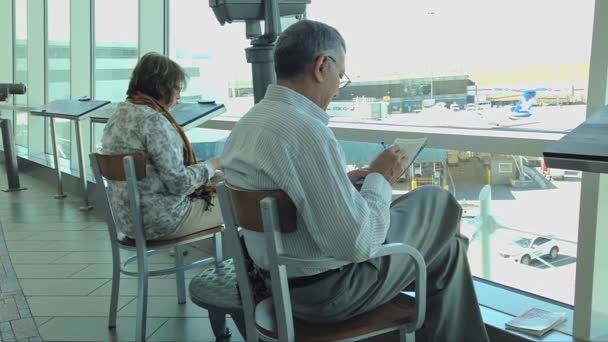 Mensen wachten op hun vlucht op de luchthaven van yvr — Stockvideo