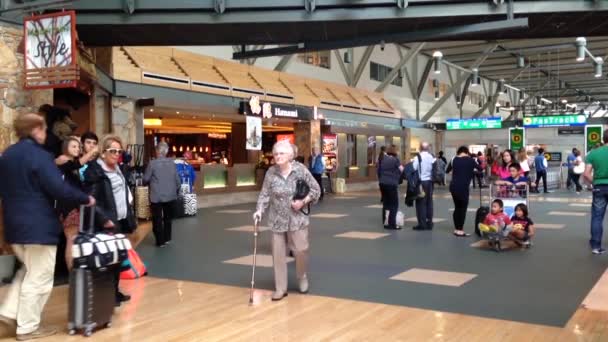 Slow motion van passagiers met bagage binnen yvr luchthaven — Stockvideo