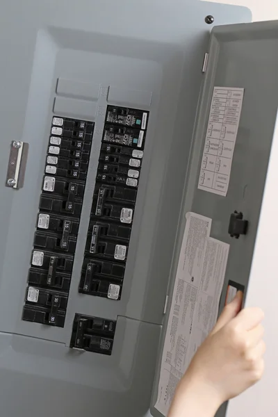 Woman turning off the light-switch in the hall — Stock Photo, Image