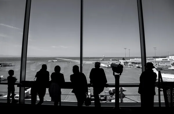 People inside YVR airport watching air canada airplane with black and withe toned — Stock Photo, Image