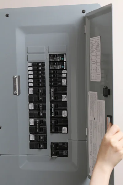 Vrouw controleren automatische zekeringen op elektrische bedieningspaneel — Stockfoto