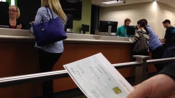 Mujer sosteniendo un cheque dentro del banco TD — Vídeos de Stock