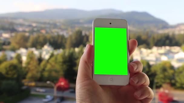 Człowiek posiada puste inteligentny telefon z zielonego ekranu dla niestandardowej treści. — Wideo stockowe