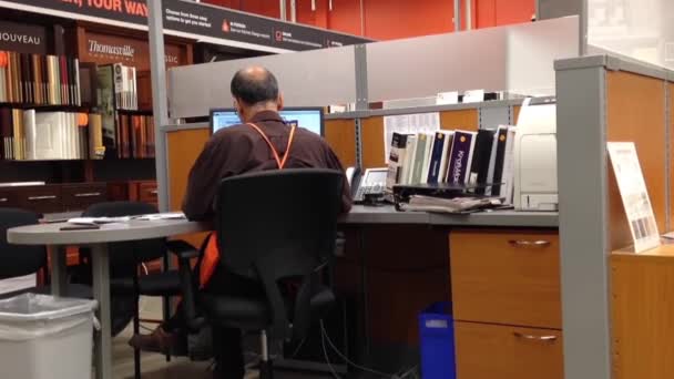 Hombre Homedepot trabajador escribiendo información en la computadora dentro de la oficina de la tienda — Vídeo de stock
