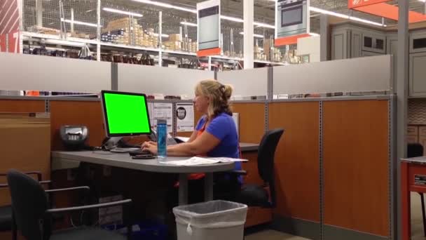 Atractiva trabajadora Homedepot femenina escribiendo información con computadora de pantalla verde — Vídeo de stock