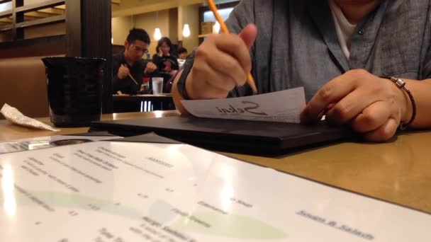 Женщина заказывает еду в японском ресторане — стоковое видео