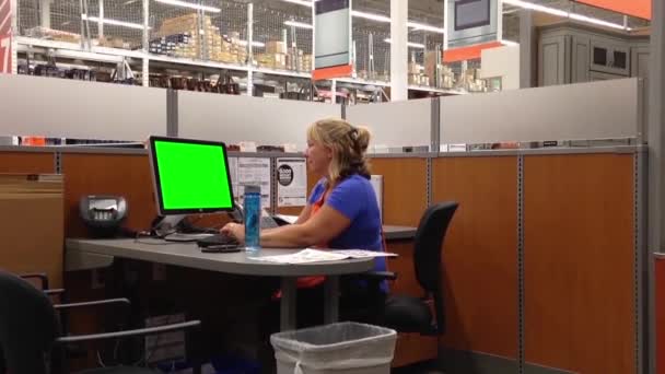 Attractive female Homedepot worker typing information with green screen computer — Stock Video