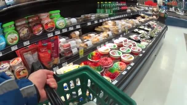 食品を購入するためにバスケットを運ぶ手 — ストック動画