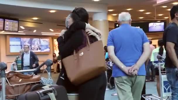 Woman hugging her friend at internation arrival lobby — Stock Video