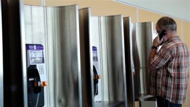 Geçen insanlar ile ortak ödeme telefonu ile konuşan adam