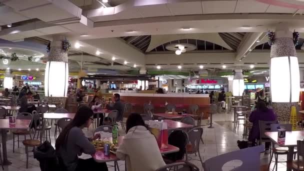 Gente disfrutando de la comida en la cafetería moderna del patio de comidas . — Vídeos de Stock