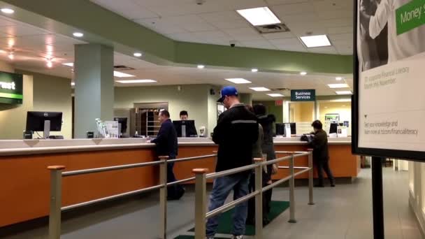 People at a service counter talking to the teller — Stock Video