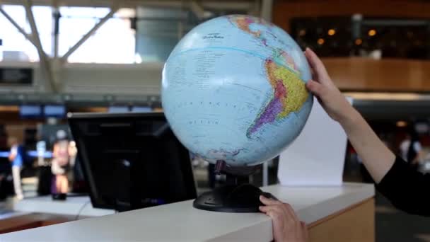 Woman checking globe map at information desk inside YVR airport — Stock Video