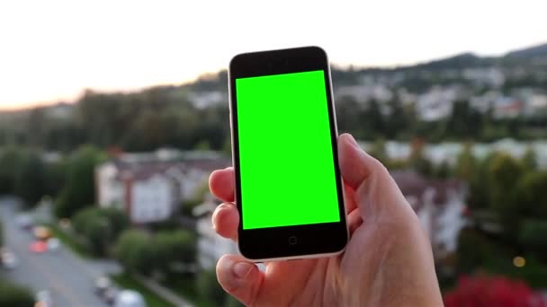 Muž drží prázdný chytrý telefon s zelenou obrazovkou pro vlastní obsah. — Stock video