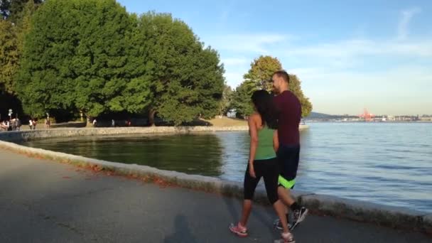 Folk jogga bredvid sjön på Stanley park — Stockvideo