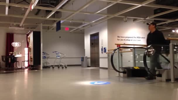 Les gens montent l'escalier roulant à l'intérieur d'Ikea — Video