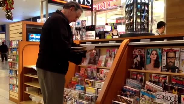 Close up man choosing magazine to buy at newspaper booth — Stock Video