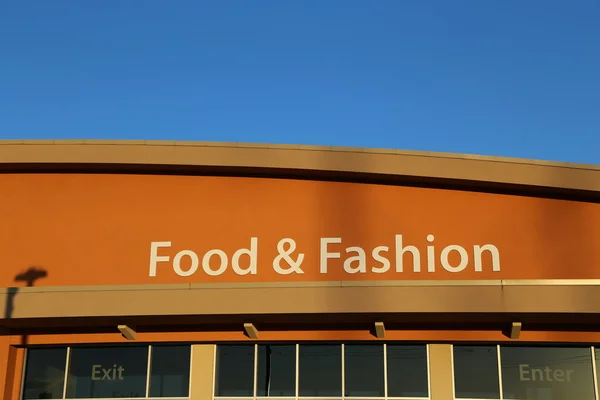 Еда и модный знак на здании — стоковое фото