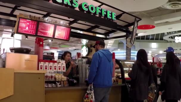 La gente hace cola para comprar café en Starbucks con un gran ángulo de tiro — Vídeo de stock
