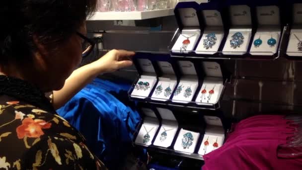 Mujer comprando audífonos accesorios de regalo dentro de la tienda de regalos . — Vídeos de Stock