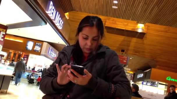 Закрыть женщину, читающую сообщения с мобильного телефона в сезон рождественских покупок — стоковое видео